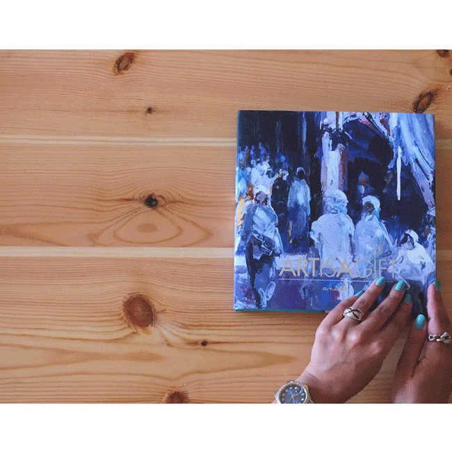 A book where a colorful painting covers it, it has all the artist paintings that illustrated into a scarf .